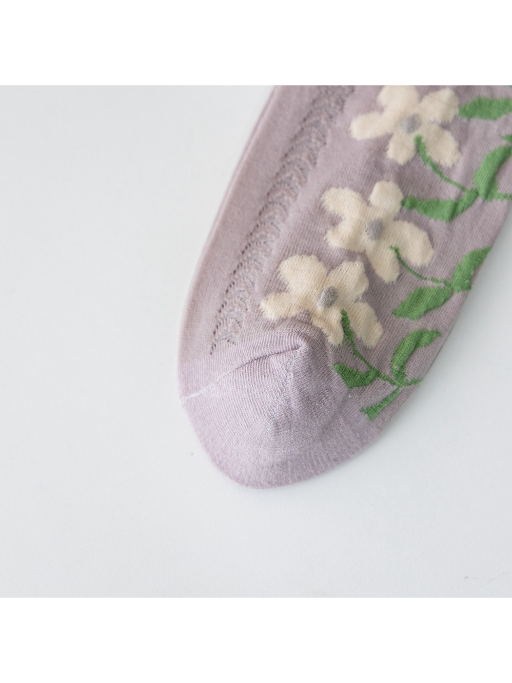 Close-up of the light purple sock toe, floral motif and openwork panel