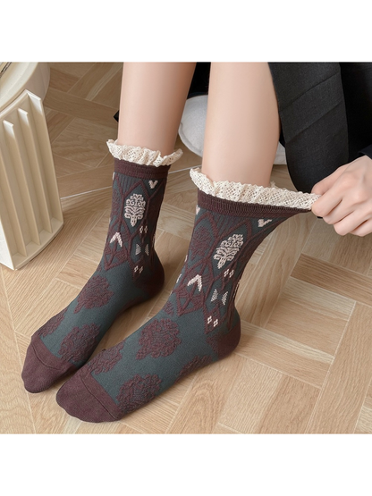 Close worn view of dark green patterned socks with stretched lace-trimmed cuffs