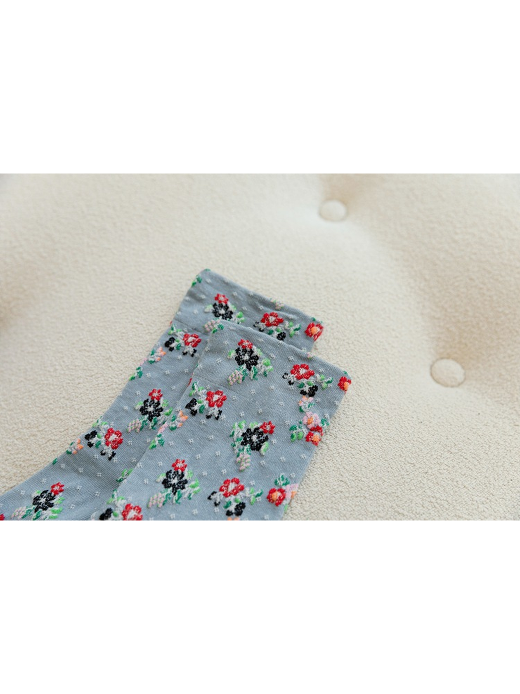 Close-up of floral clusters and dotted texture near the sock cuff