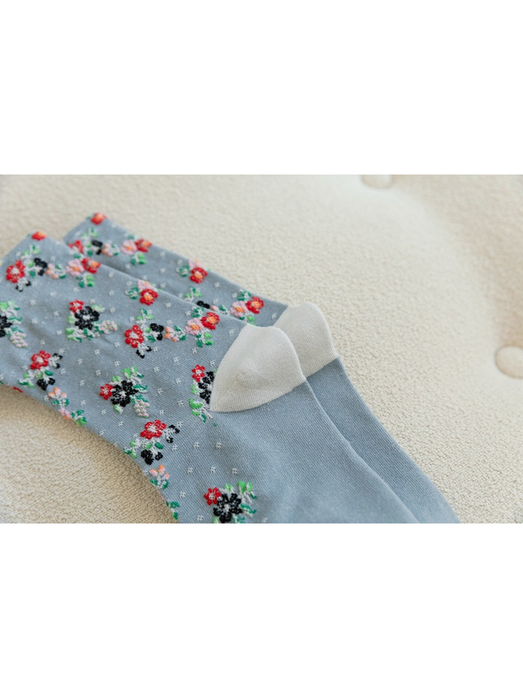 Close-up of pale contrasting heel panels on light blue floral socks
