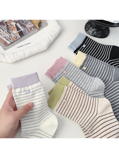 Five striped crew sock colors arranged together on a white table