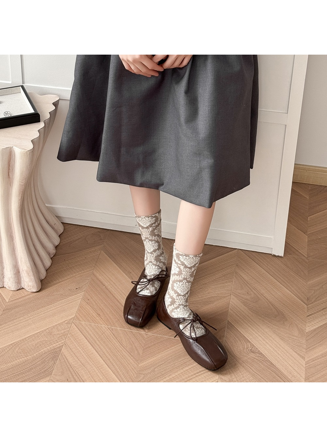 Greige patterned crew socks styled with brown lace-up shoes