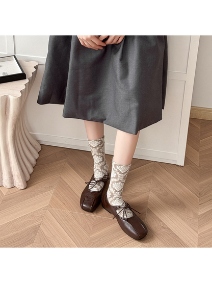 Greige patterned crew socks styled with brown lace-up shoes