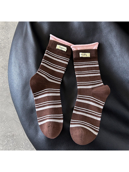 Brown crew socks with gray stripes and pink rolled cuffs