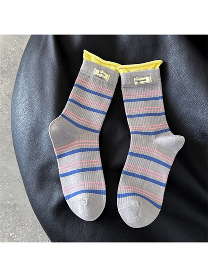 Gray crew socks with blue and pink stripes and yellow cuffs