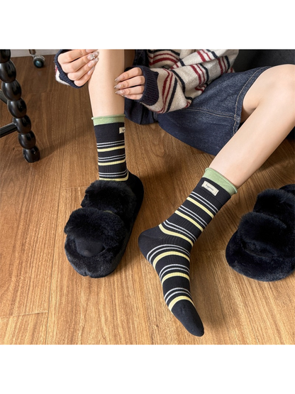 Black striped crew socks styled with plush slippers