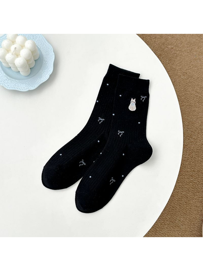 Black crew socks with embroidered animal, bow and dot motifs