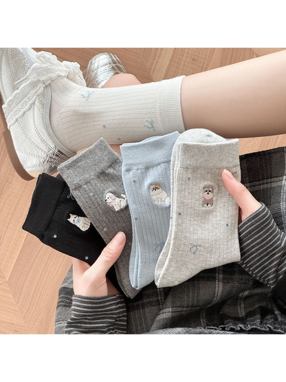 Black, gray, white and light blue embroidered crew socks displayed together