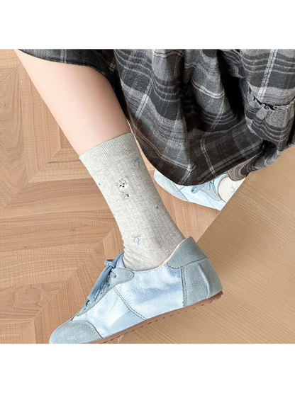 Light gray embroidered crew sock styled with a blue shoe
