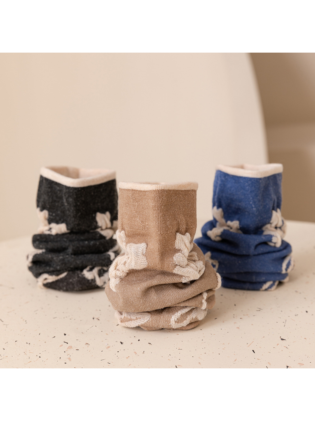Dark gray, taupe and blue botanical socks gathered to show their drape