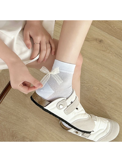 Light blue ankle sock with an ivory lace bow worn with a white shoe