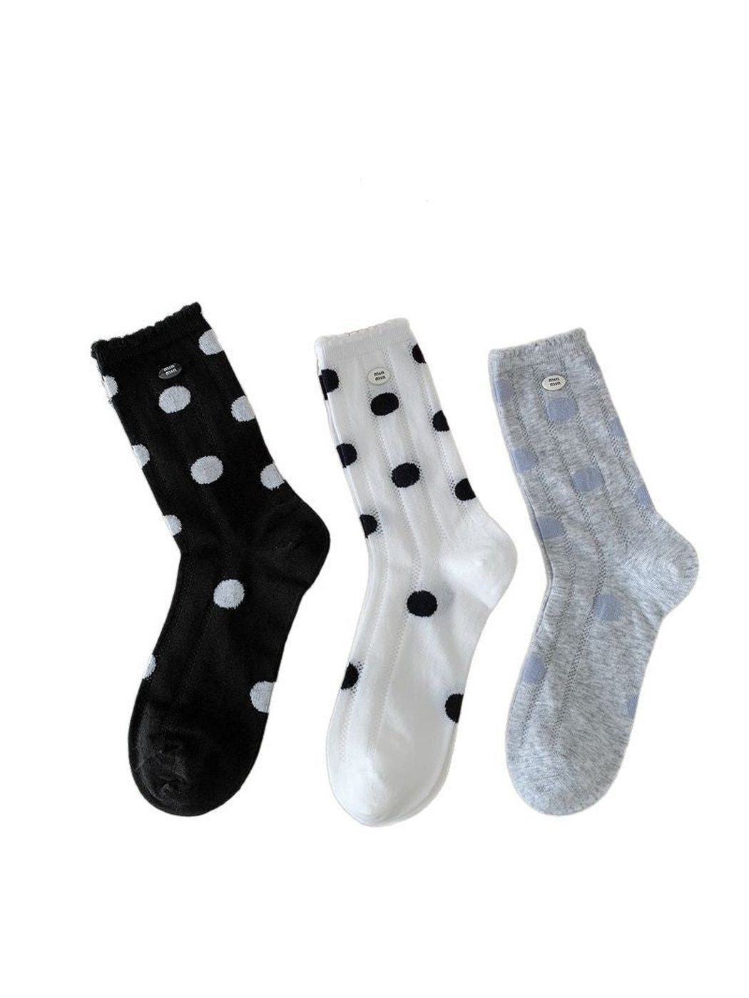 Black, white and light gray polka-dot crew socks displayed together