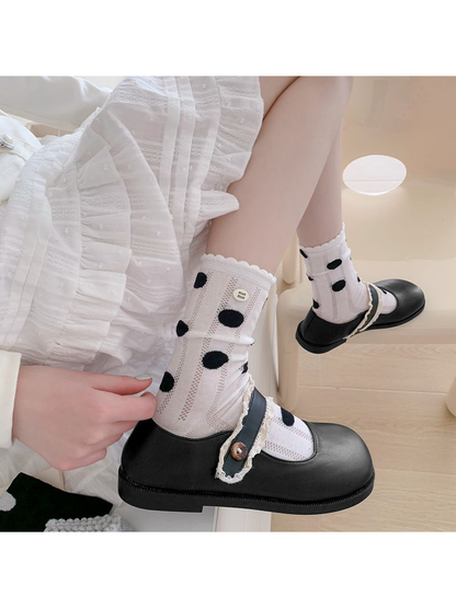 White polka-dot crew socks styled with black Mary Jane shoes
