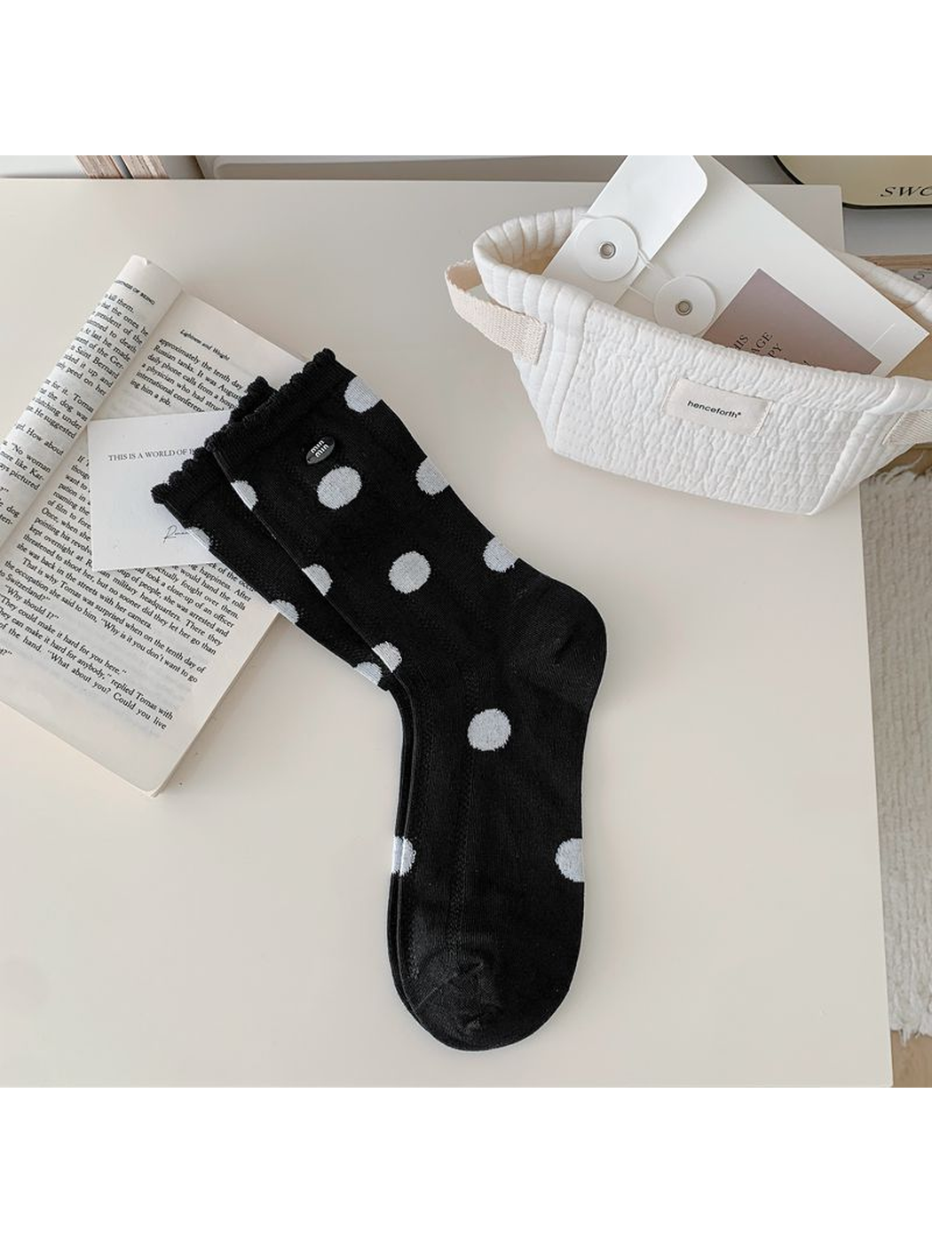 Black polka-dot crew sock displayed flat