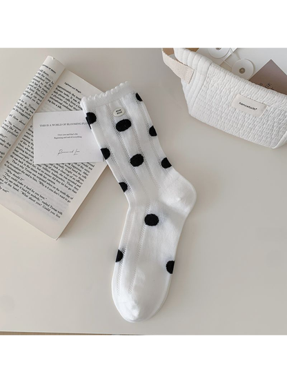 White crew sock with black polka dots displayed flat