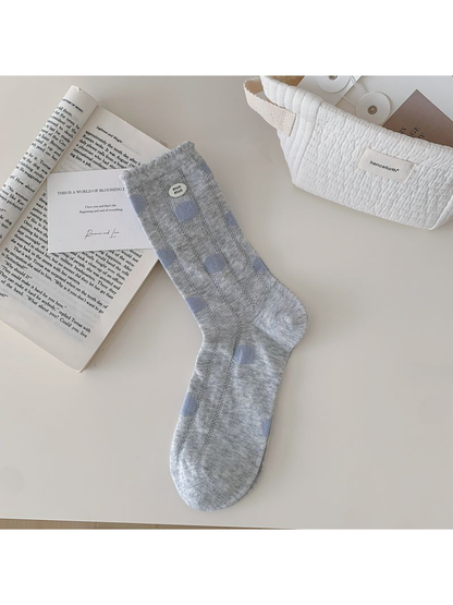 Light gray crew sock with pale blue polka dots displayed flat