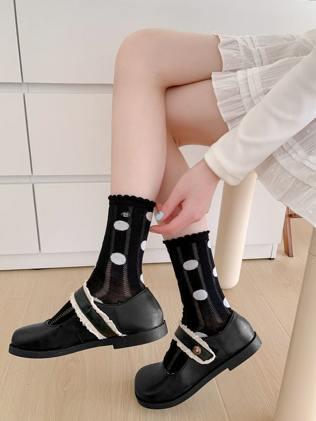 Black polka-dot crew socks styled with black Mary Jane shoes