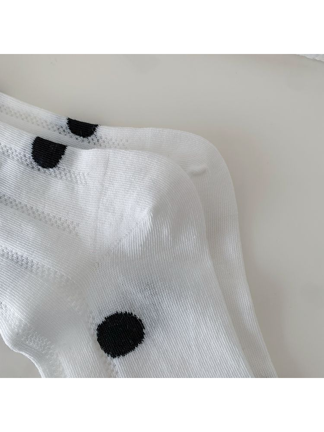 Close-up of the white sock's shaped heel and fine knit texture