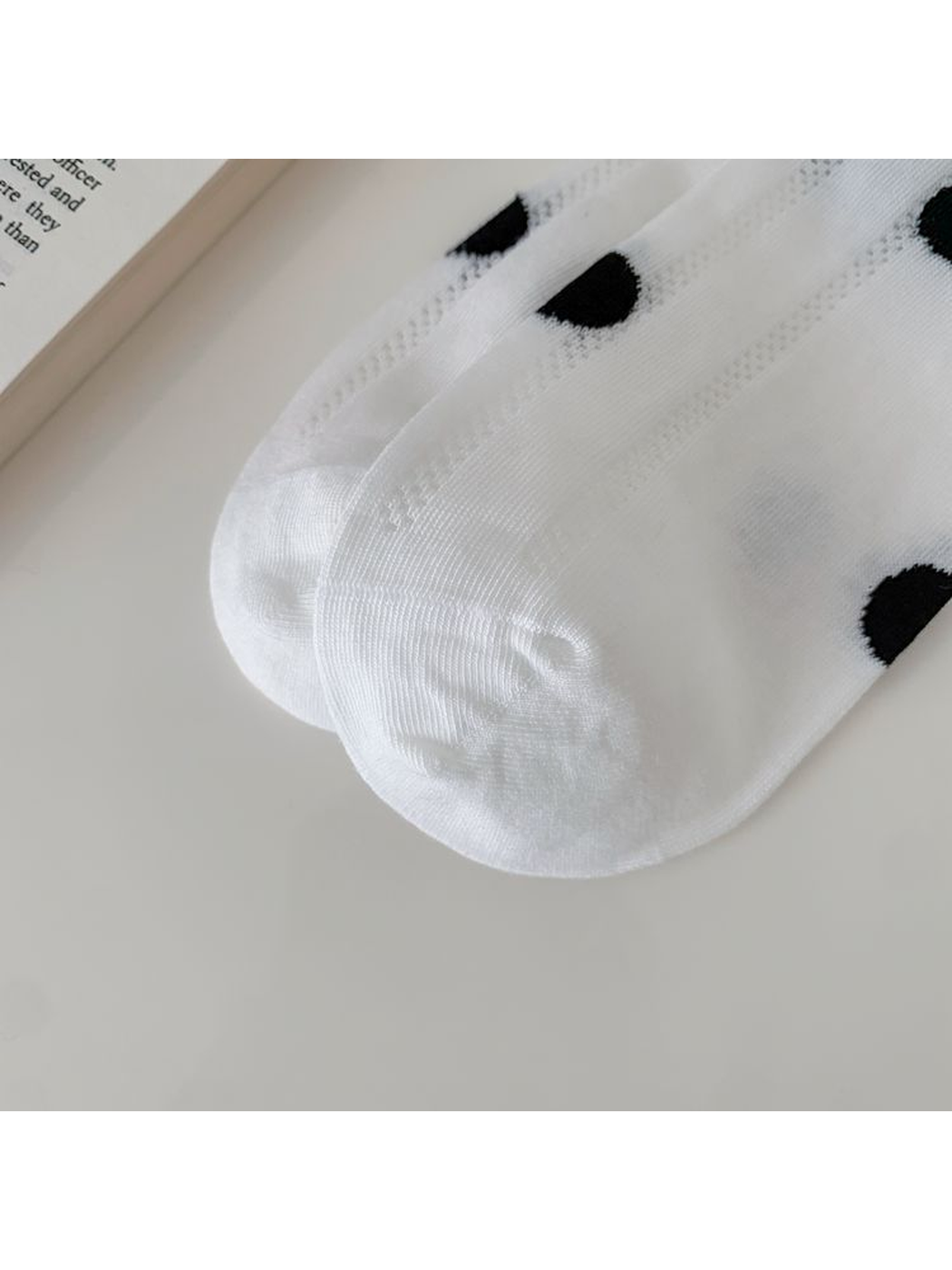 Close-up of the white sock's rounded toe and fine knit texture