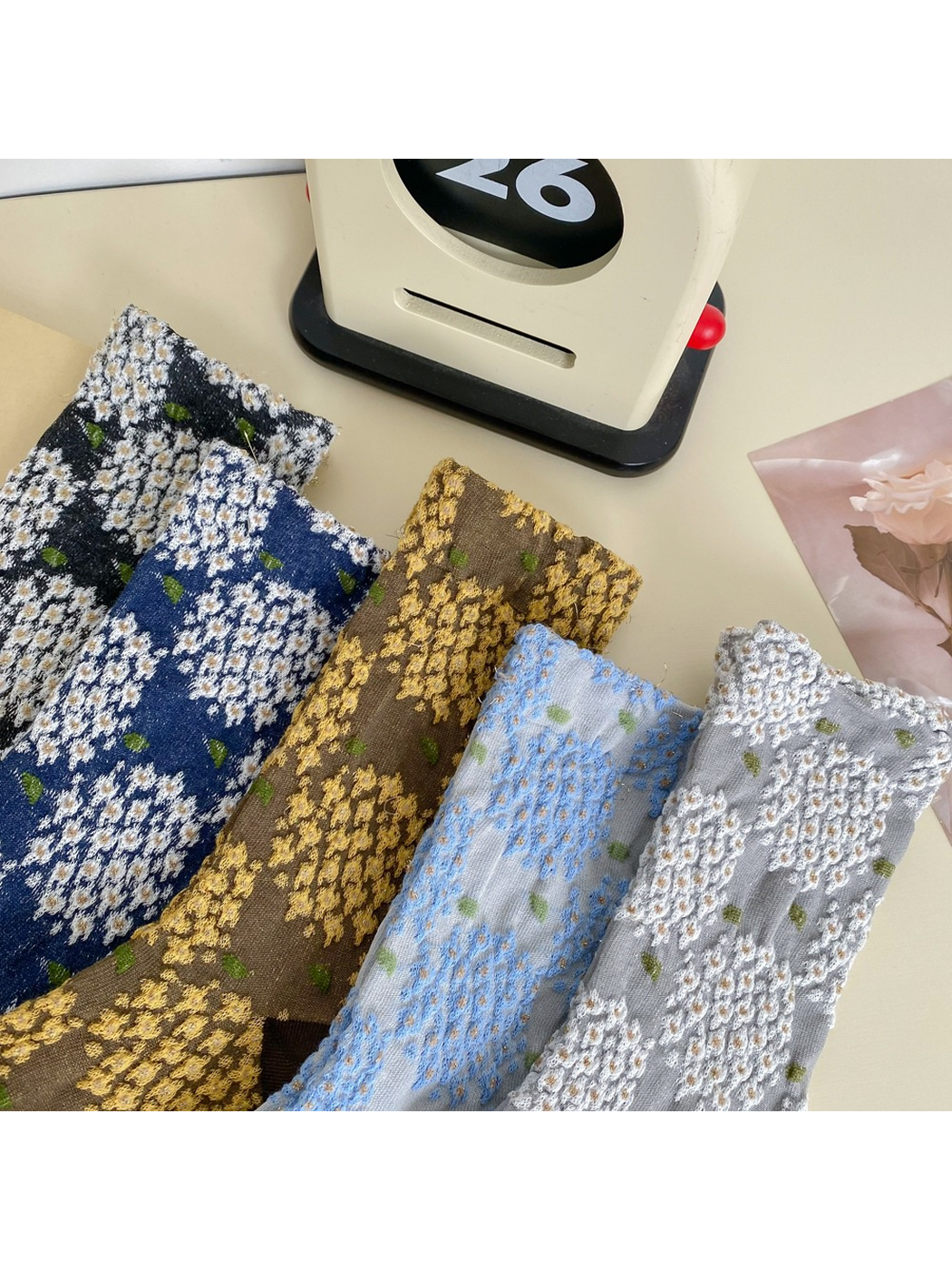 Close view of the raised floral texture across five sock colors