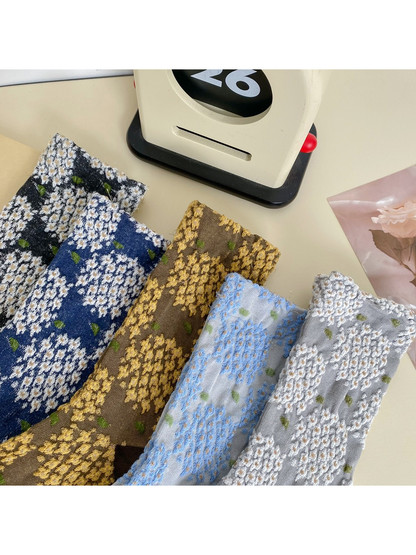 Close view of the raised floral texture across five sock colors