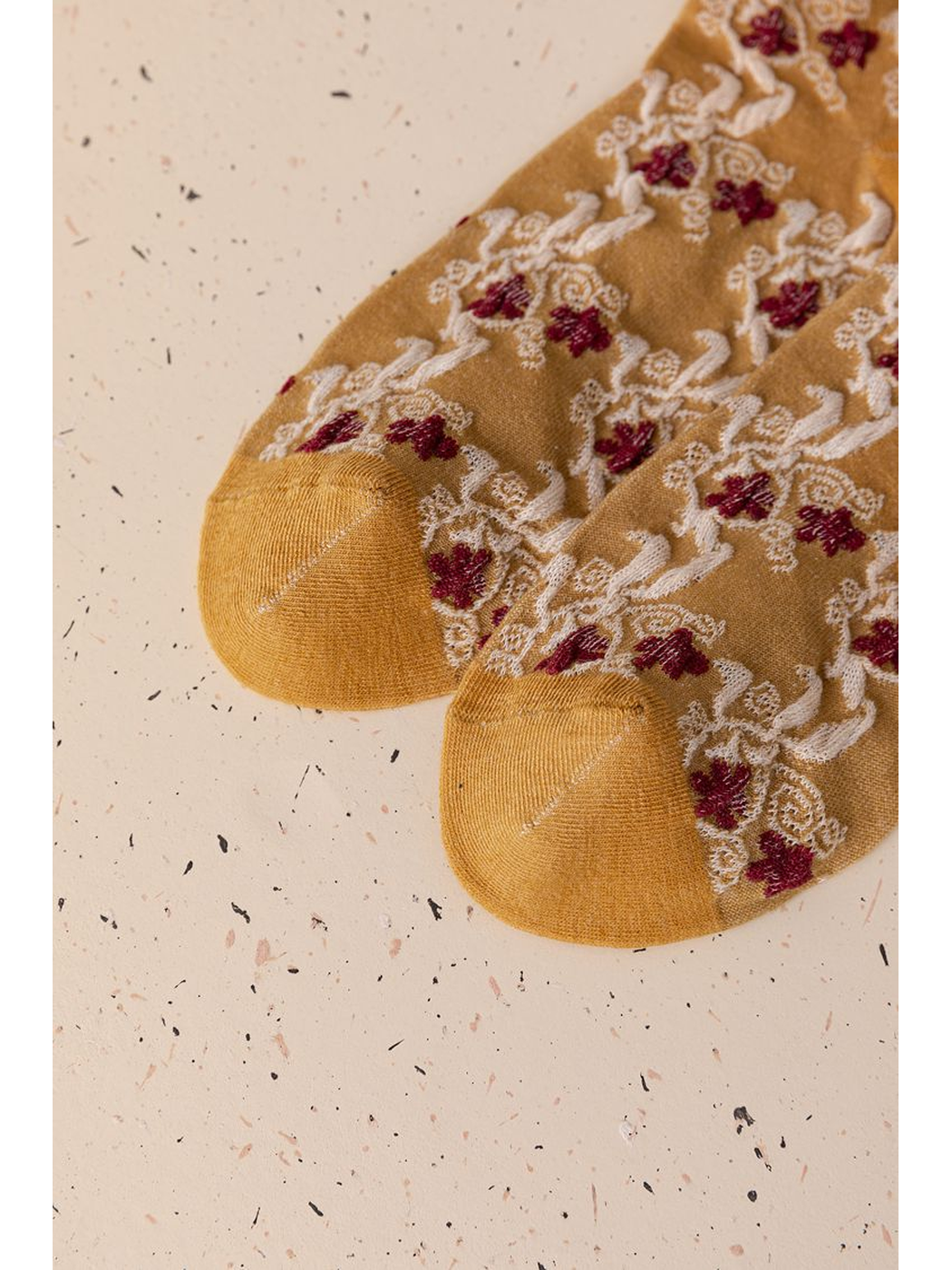 Close-up of the mustard yellow sock toes and floral pattern