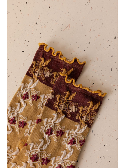 Close-up of the burgundy floral cuffs and mustard ruffled edges