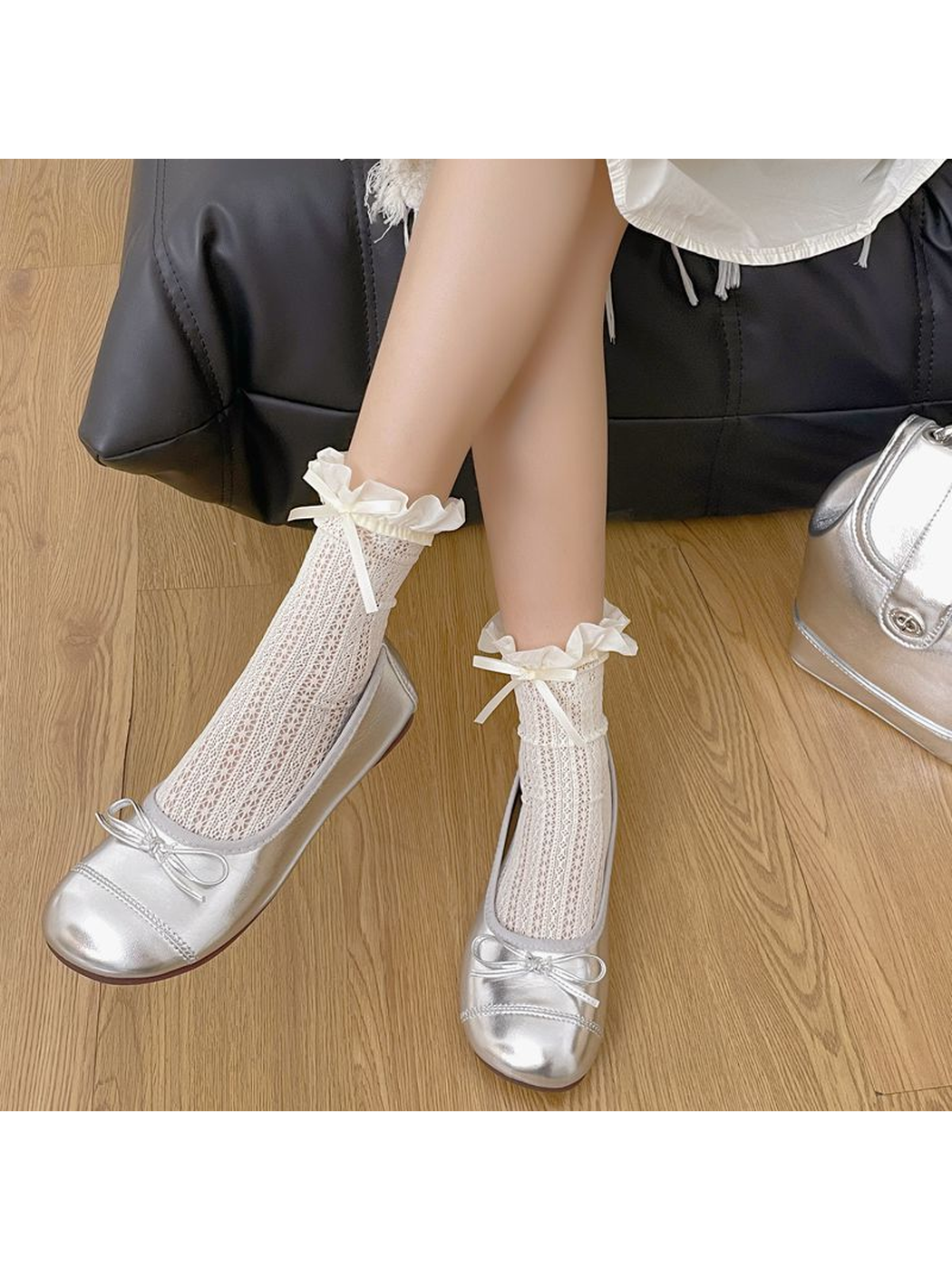 White openwork crew socks with ruffled cuffs and bows worn with silver flats