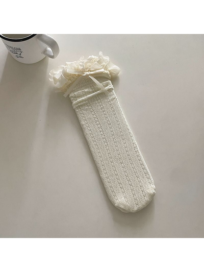 Ivory openwork crew sock with a ruffled cuff and ribbon bow