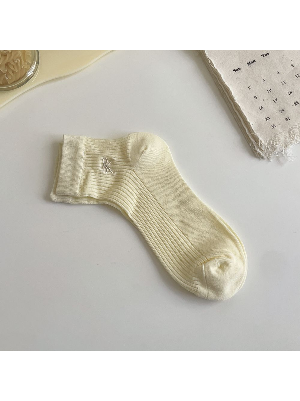 Pale yellow ribbed ankle sock with white embroidered bow