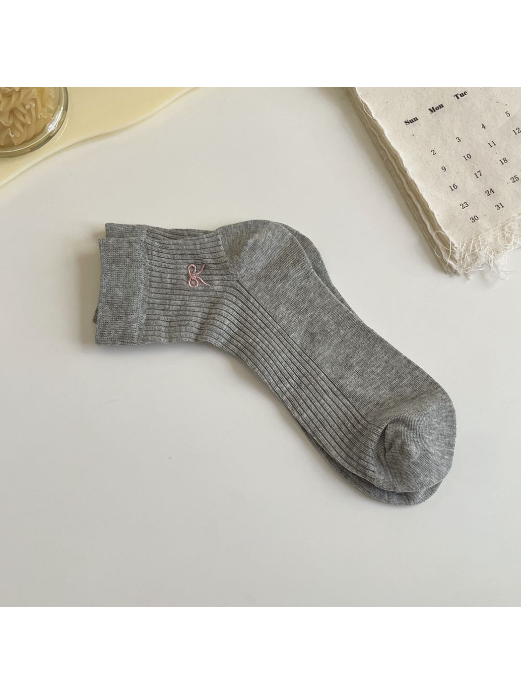 Light gray ribbed ankle sock with pink embroidered bow