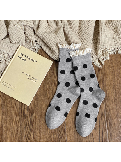 Light gray crew socks with black polka dots and cream lace-trimmed cuffs