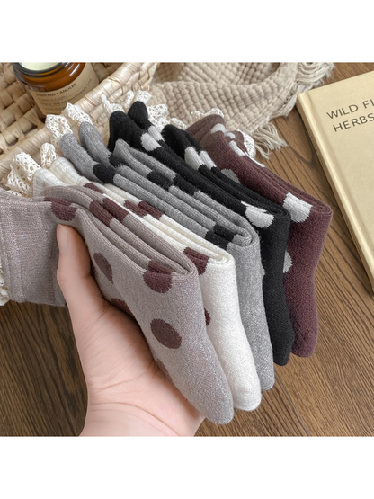 Side view of folded polka dot socks in five colors showing the lace-trimmed cuffs