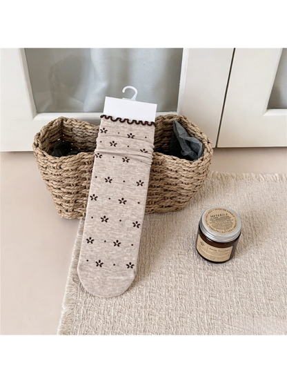 Beige crew sock with dark floral motifs, dots and a wavy cuff