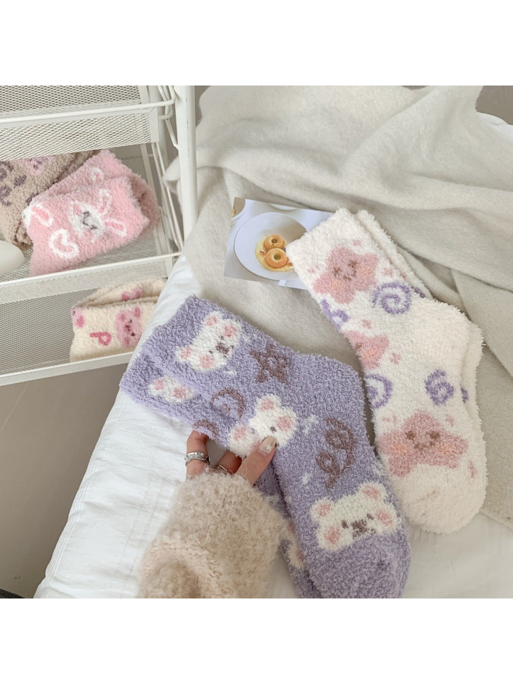 Purple and white fuzzy crew socks styled on a bed