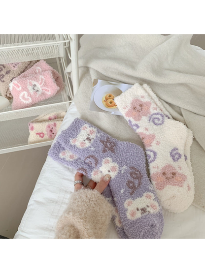 Purple and white fuzzy crew socks styled on a bed