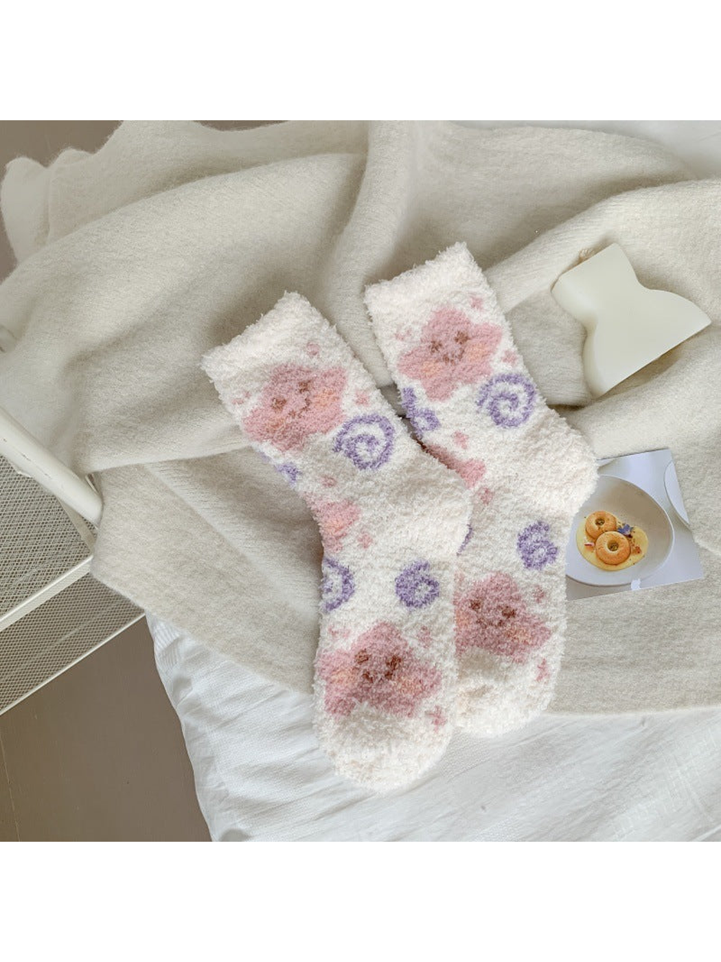 White fuzzy crew socks with pink animal faces and purple spirals