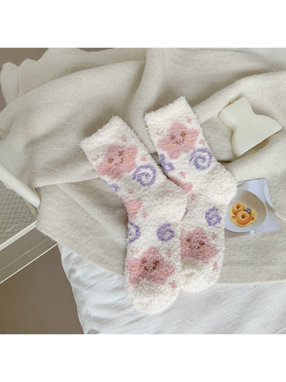 White fuzzy crew socks with pink animal faces and purple spirals