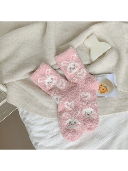 Light pink fuzzy crew socks with white rabbit faces and bows