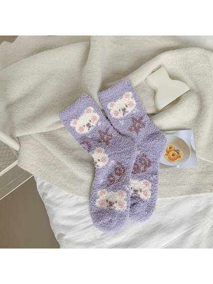Light purple fuzzy crew socks with white animal faces and brown motifs