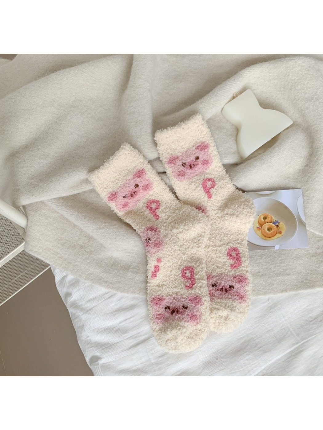Cream fuzzy crew socks with pink animal faces and curled motifs