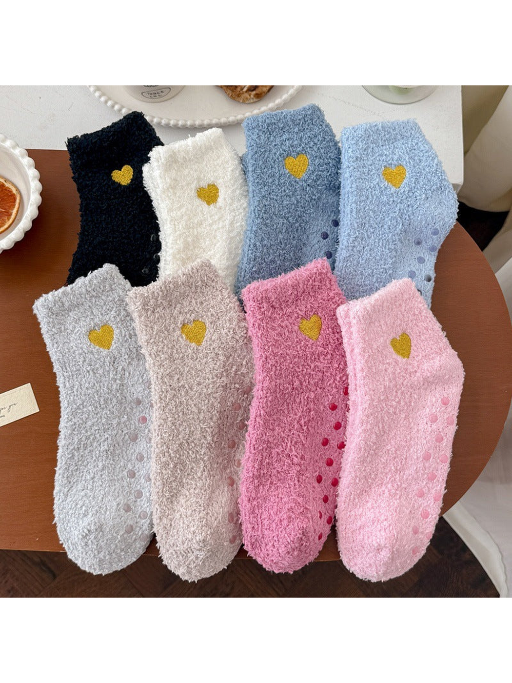 Eight colors of fuzzy ankle socks with yellow heart embroidery displayed together
