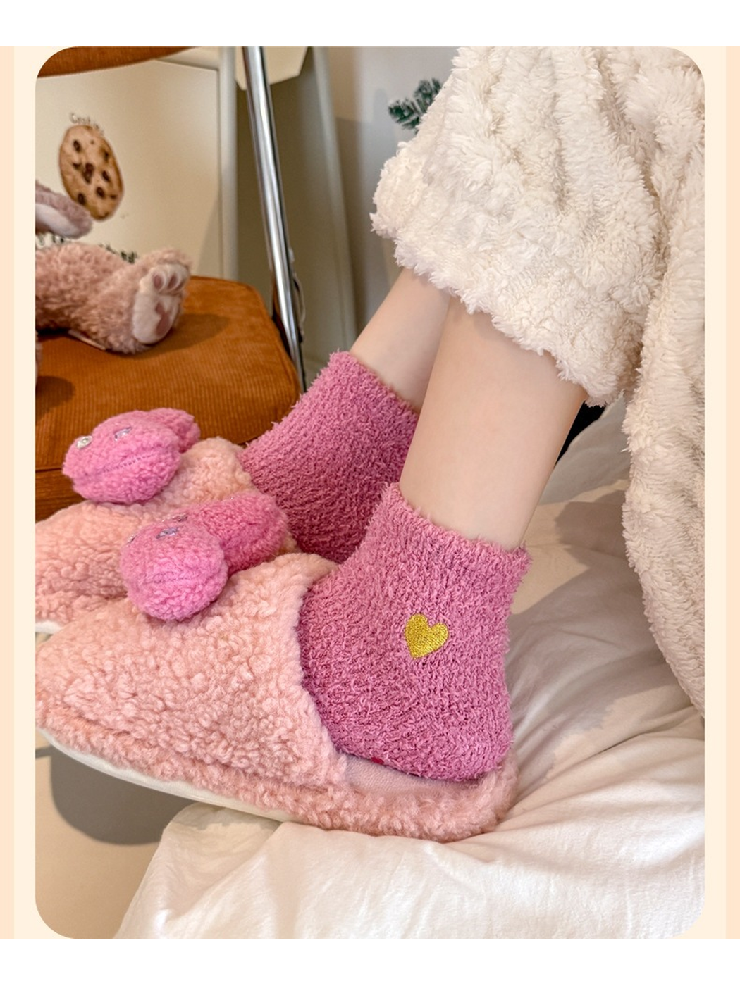 Dusty pink fuzzy ankle socks with yellow heart embroidery worn with plush slippers