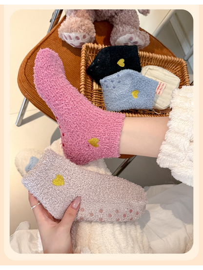 Dusty pink fuzzy ankle sock worn beside a taupe sock showing the raised sole dots