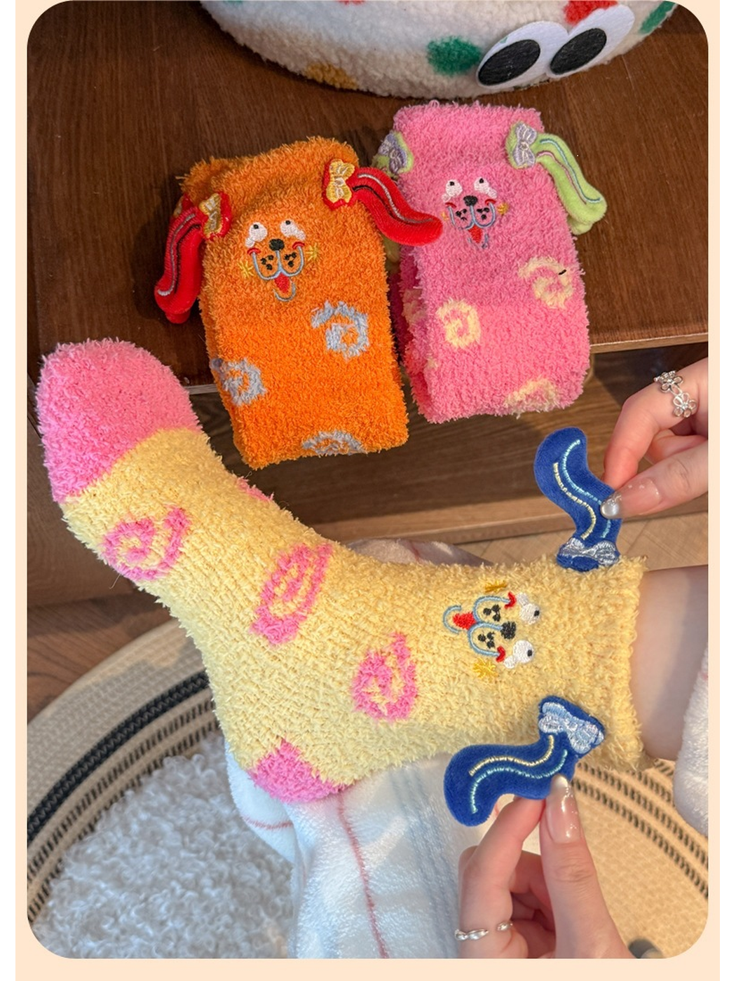Pale yellow fuzzy sock stretched by hand with pink and orange styles nearby