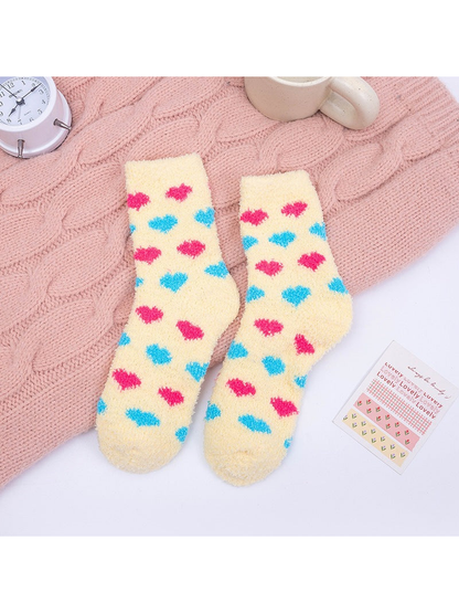 Yellow fuzzy crew socks with pink and blue heart motifs