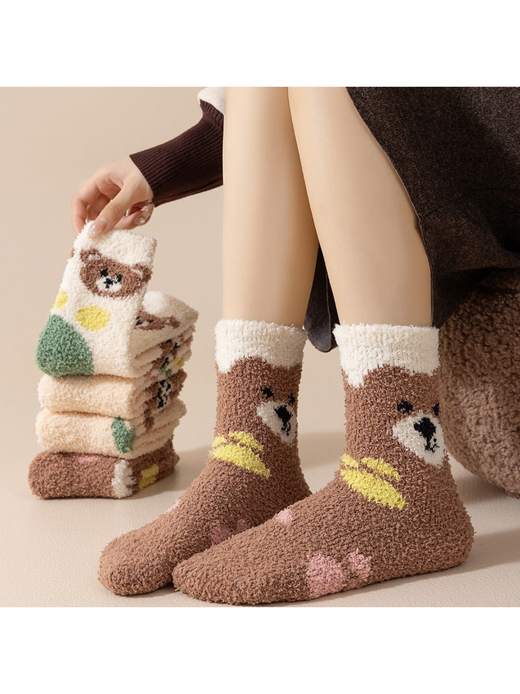 Brown bear crew socks worn beside a stack of assorted fuzzy sock designs
