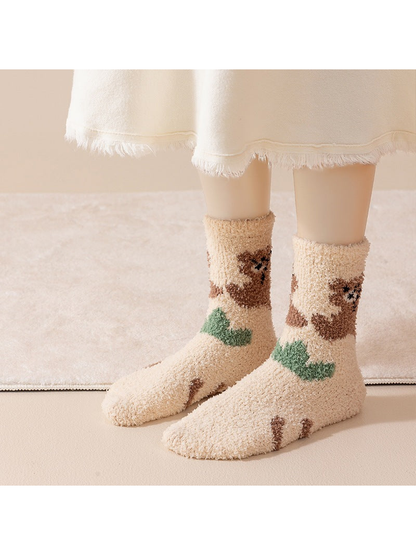 Ivory fuzzy crew socks with brown bear and green leaf motifs, worn view