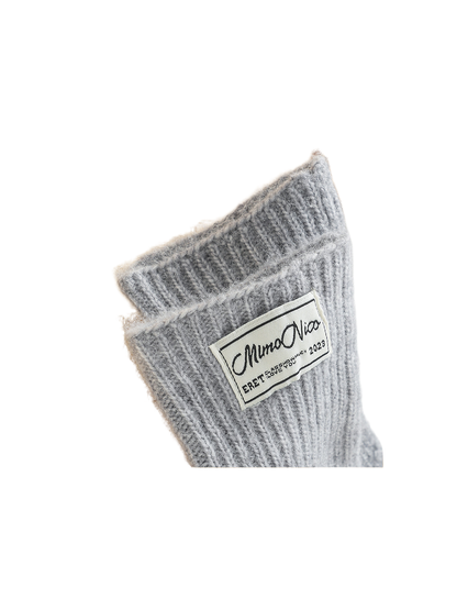 Close-up of the light gray glove cuff, ribbed texture and woven label
