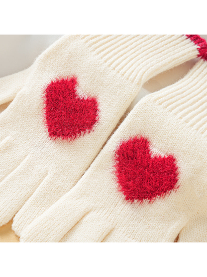 Close-up of fuzzy red heart patches on ivory gloves